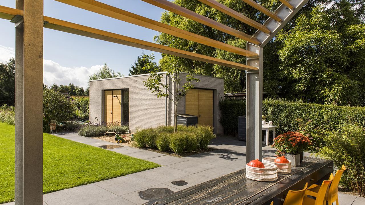 Bijgebouw in stijl van het woonhuis gezien vanaf het terras