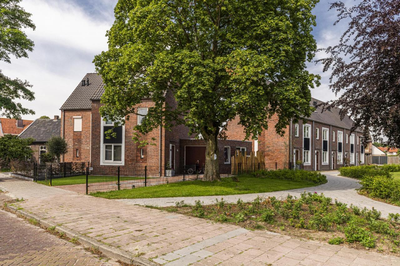 Voorzijde met links de twee-kapper en rechts de rijwoningen