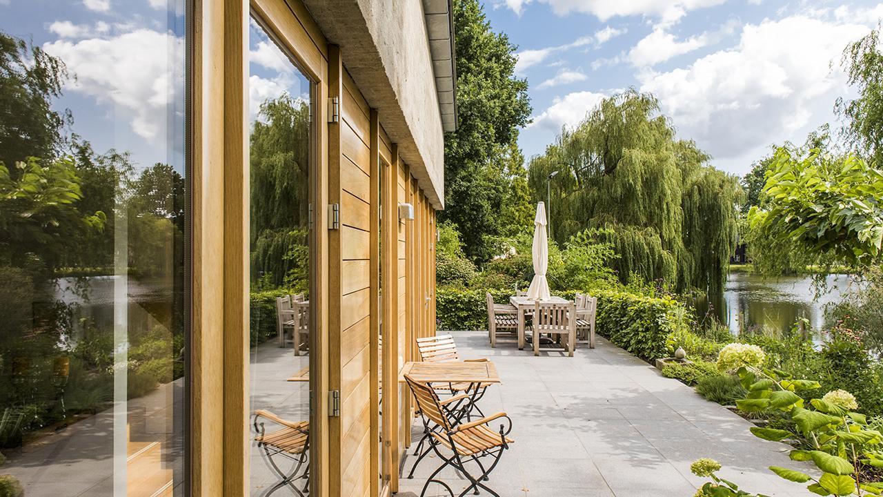 De lange eiken pui met het uitzicht vanuit de tuin